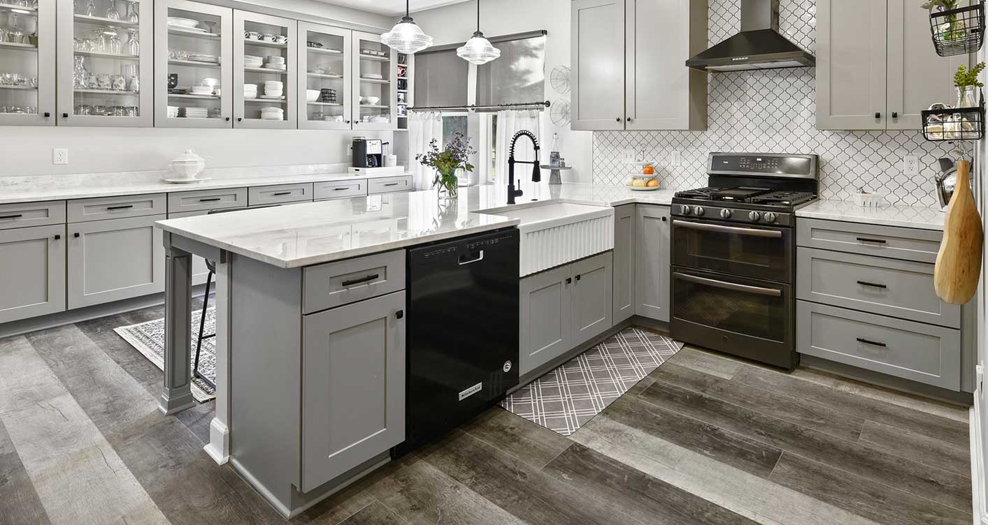 Gray shaker kitchen with black stainless range and dishwasher installed by Greystone