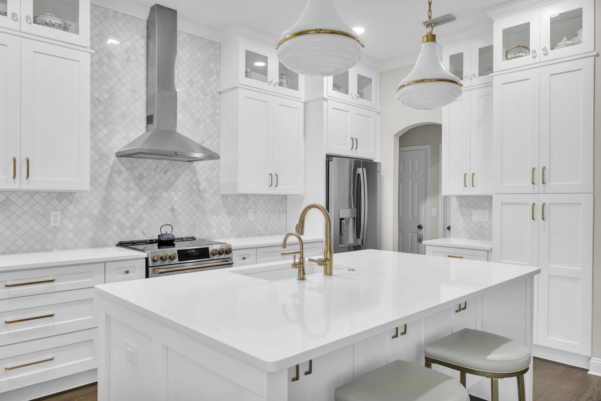 White kitchen with island and stone countertops