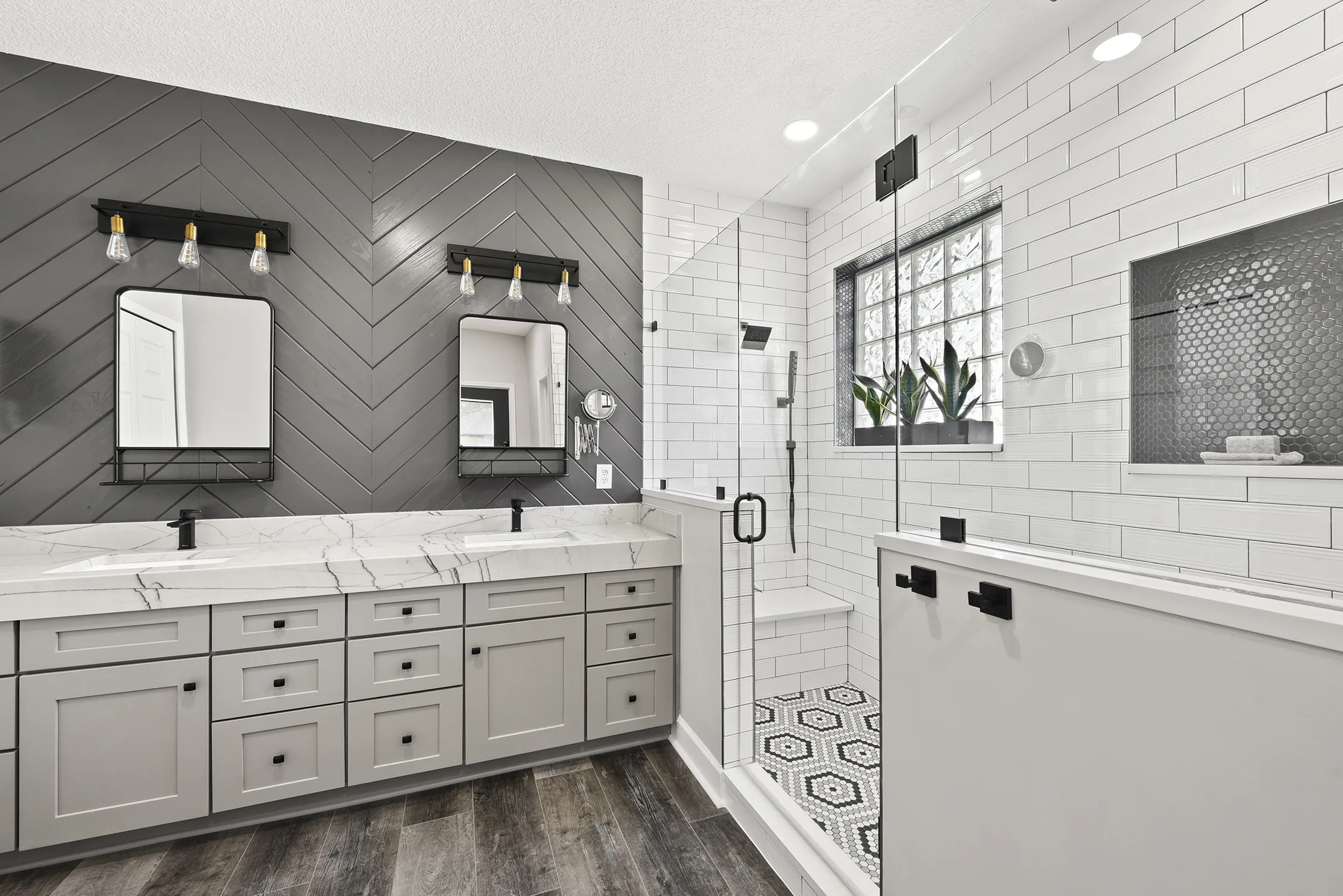 Double vanity with chevron accent wall and glass shower