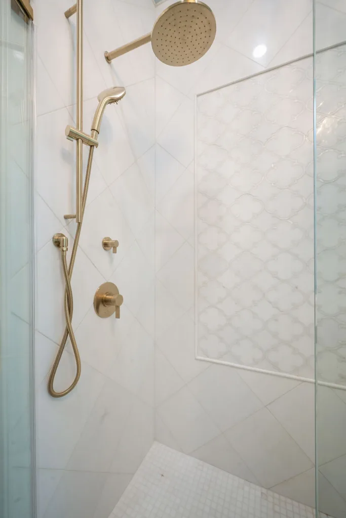 Walk-in shower with brushed gold fixtures and large format tile