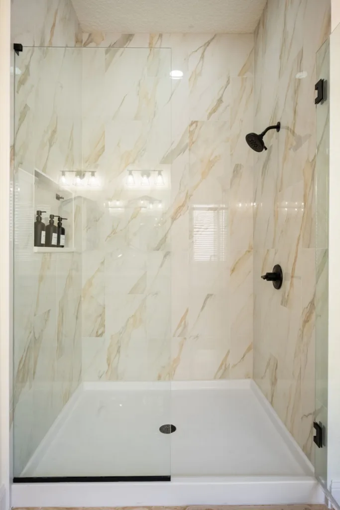 Marble-look walk-in shower with a built-in niche in a Jacksonville bathroom remodel
