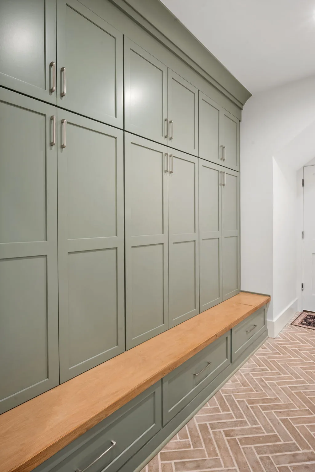 Custom built-in storage with sage cabinetry and bench