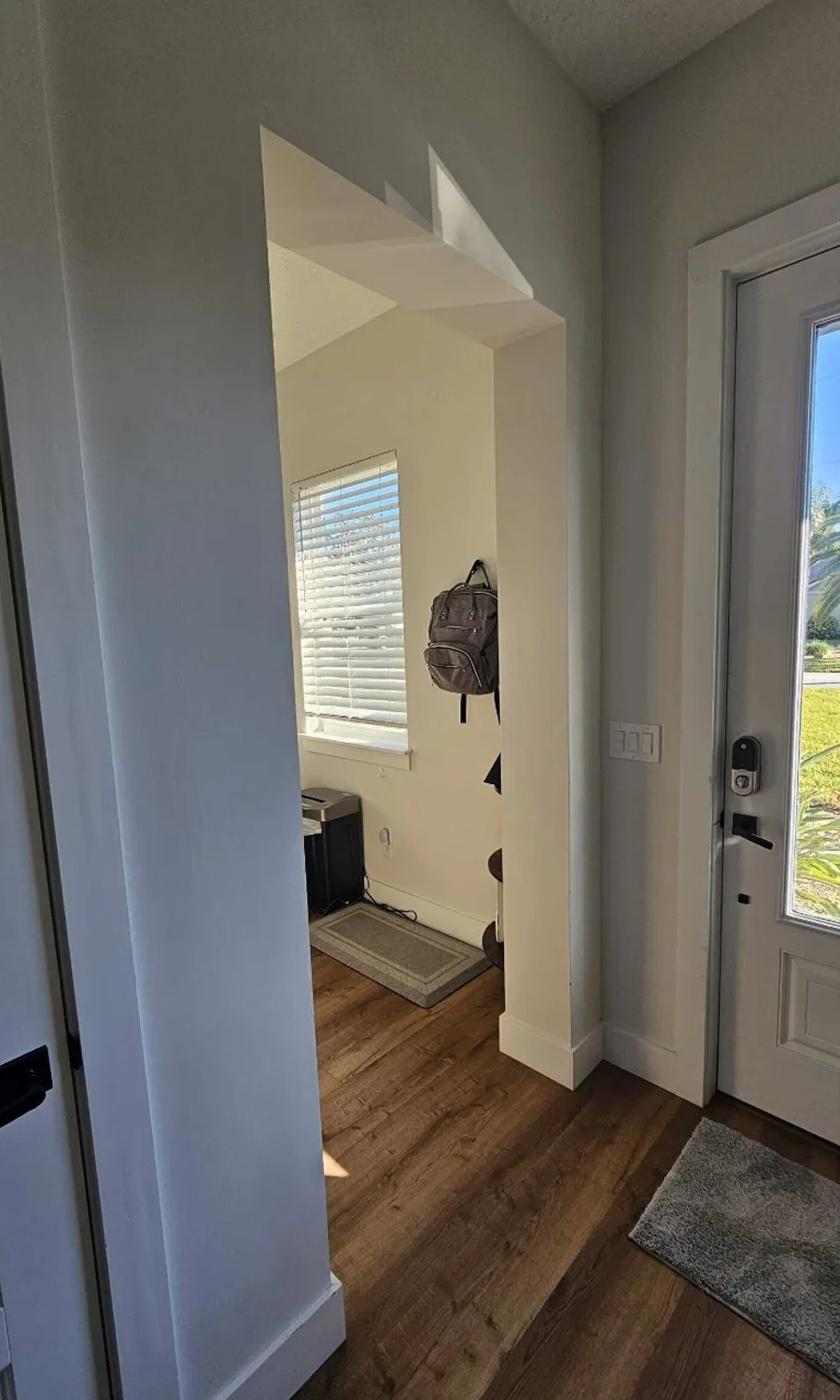 Entry before remodel with an open drywall archway into a small office