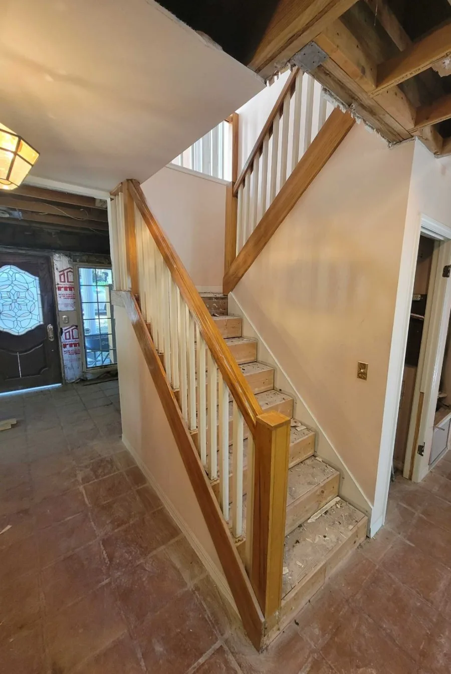 Entry staircase before renovation with worn treads, oak handrail and white wood balusters
