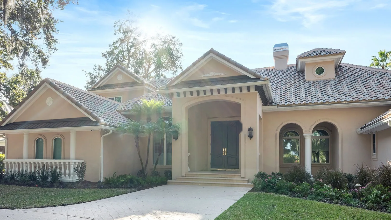 After: new arched windows, warm stucco, refined entry trim, balustrades and columns