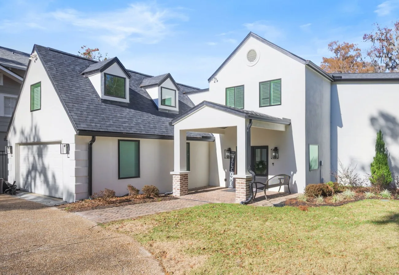 After: the renovated front with a new covered entry, shutters and herringbone walk