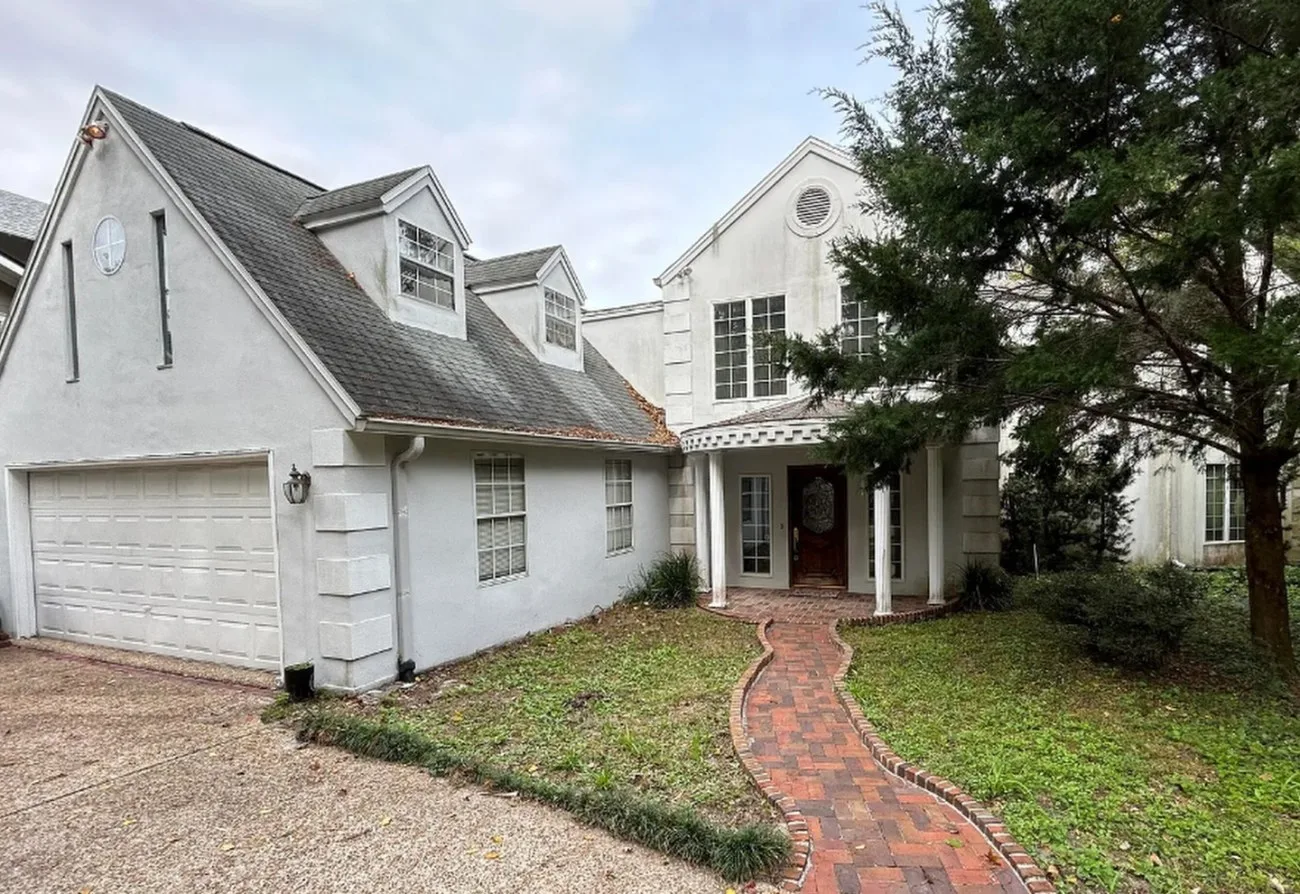 Before: the front of the home with a dated portico and brick walk