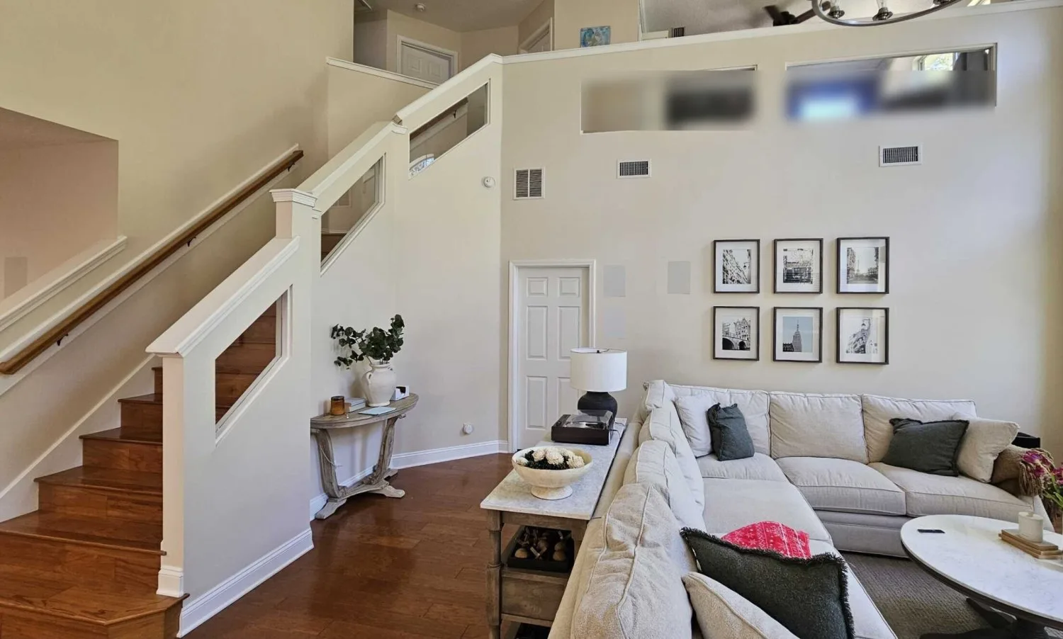 Great room staircase before renovation with half walls, cutouts and an oak handrail