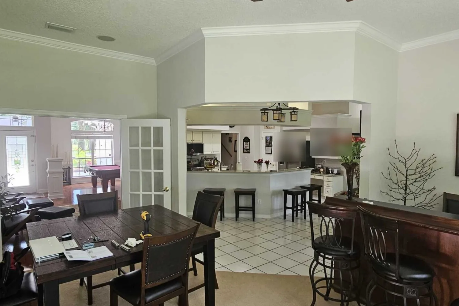 Game room before remodel with a wall and small opening into the kitchen