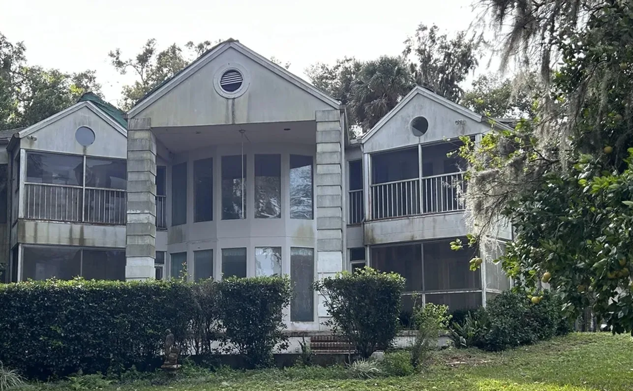 Before: the two-story home with screened porches and stained siding