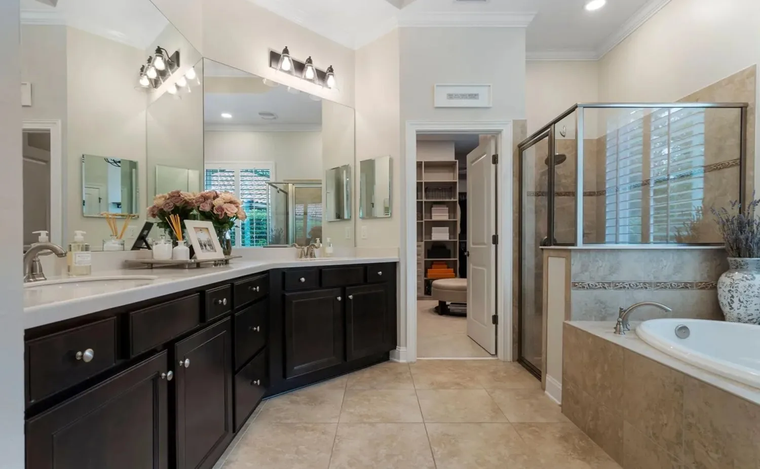 Primary bathroom before remodel with dark cabinets and framed shower