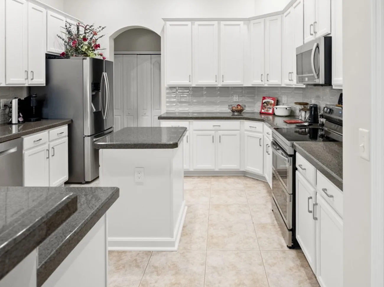 Same kitchen after cabinet refinishing in white with the original countertops kept